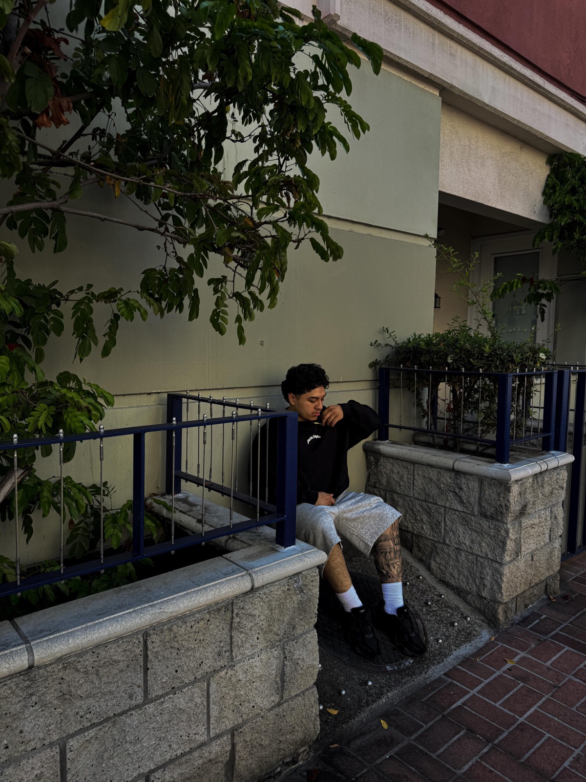Lucas sitting on a street ledge